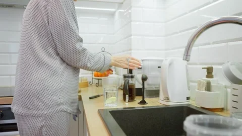 Senior lady making warm lemon water for a healthy morning routine. Stock Footage 314850610