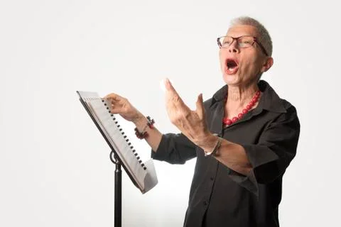 Senior lady practicing her singing skill, elderly voice coach si Stock Photos