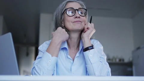 Senior lady procrastinating on work, looking at window instead of working laptop Video stock 232518731