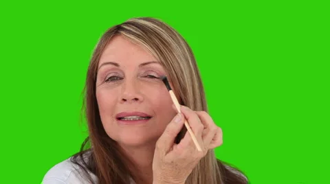 Senior lady putting on make-up Stock Footage