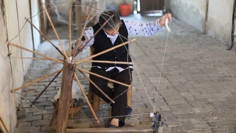 Senior Lady. Sat down spinning wool Stock Footage 97621737