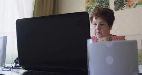 Senior lady using computer in home office, middle aged woman grandma working Stock Footage 129379420