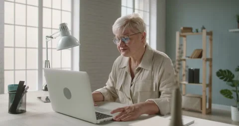 Senior lady using her laptop computer for video chatting. Mature woman talking Stock Footage 137256910