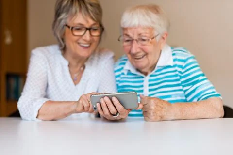Senior lady using smart phone with her mother Stock Photos