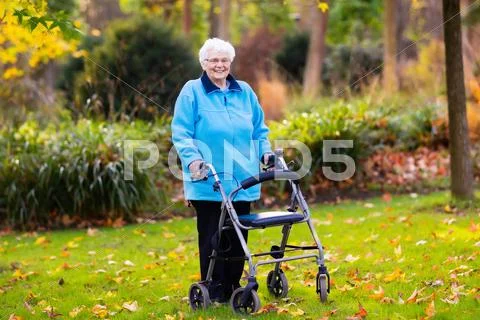 Senior lady with a walker in autumn park Stock Photos