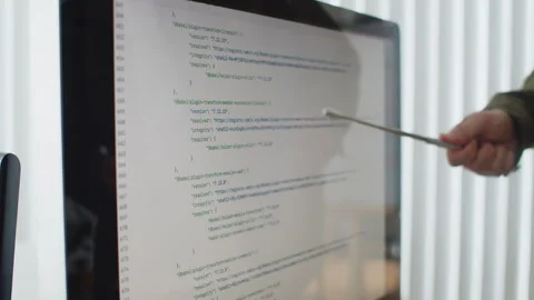 Senior Level Developer Teaching New Employees and Pointing at Screen with Code Stock Footage 256979104