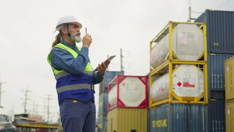 Senior logistics manager in a hard hat uses a digital tablet for inventory Stock Footage 342280551