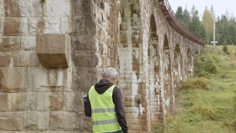 Senior male engineer to restore ancient buildings or bridges. Engineer writes Stock Footage 186845984