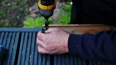 Senior Male hands fixing bracket on hand railing for wooden decking. home Video stock 140881382