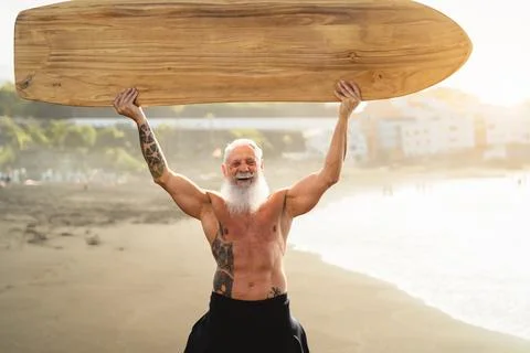 Senior male having fun surfing during sunset time - Fit retired man training Stock Photos