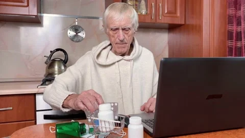 Senior male looking at computer screen, buying medicine Stock Footage 166358697