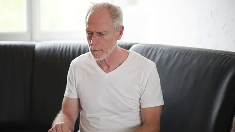 Senior man with allergy sneezing and blowing his nose Stock Footage 77245405