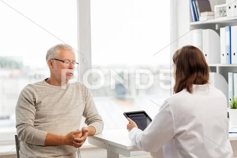 Senior man and doctor with tablet pc at hospital Stock Photos