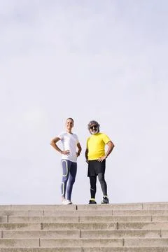 Senior man and trainer posing with hands on hips Stock Photos