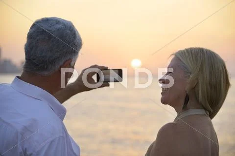 Senior man and woman using mobile phone to take photo Stock Photos
