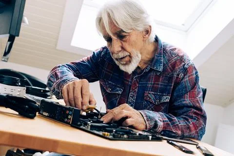 Senior Man Assembling Computer Parts Photos