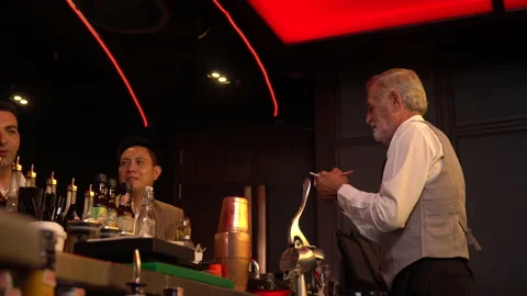 Senior man bartender standing at bar counter talking and Take an order with c Stock Footage 144996385