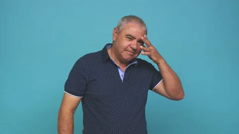 Senior man blink at the camera through fingers, embarrassed covering face Stock Footage 144217619