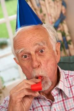 Senior Man Celebrating With Party Hat And Blower Stock Photos
