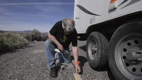 Senior man changes a wheel on an RV, trailer, driving, Stock-Footage 151657585