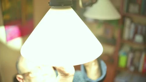 Senior man changing light bulb at home Stock Footage 329906309