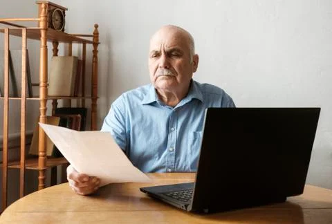 Senior man checking a handheld document Stock Photos
