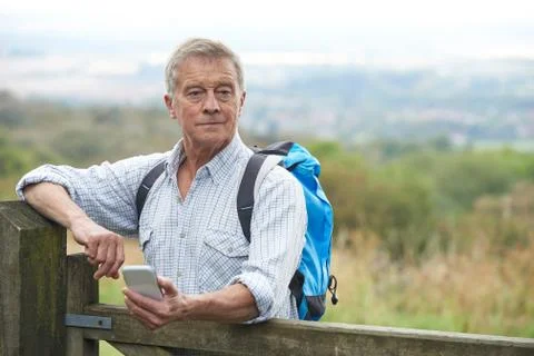 Senior Man Checking Location With Mobile Phone On Hike Stock Photos