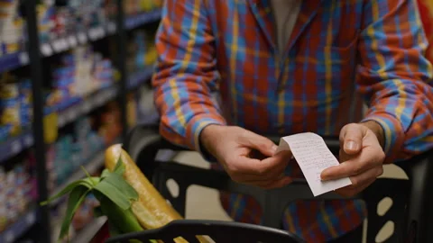 Senior man checking receipt and groceries in shopping cart Stock Footage 309064944