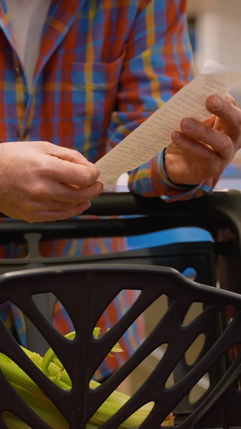 Senior man checking receipt and groceries in shopping cart Stock Footage 309066276