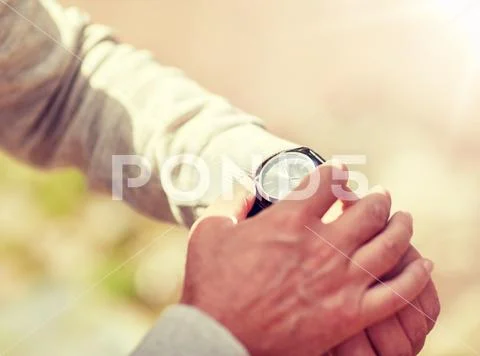 Senior man checking time on wristwatch outdoors Stock Photos