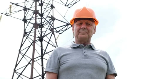 Senior man Chief Engineer in the Hard Hat looking at camera, by Transmission Tow Stock Footage 134440128
