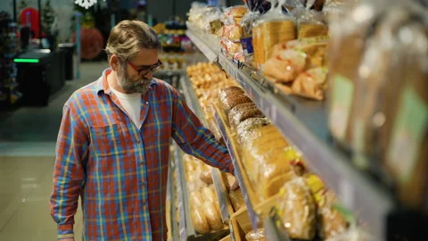 Senior man choosing bread at grocery store bakery aisle 스톡 동영상 309062801