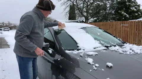 Senior man cleaning windscreen from snow Stock Footage 148553869