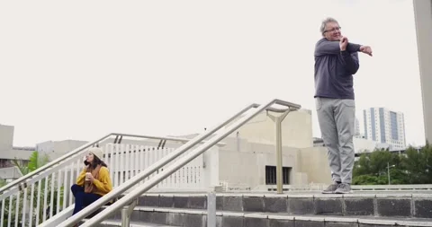 Senior man climbing outdoor platform, warming up with railing before walking Video stock 337537161