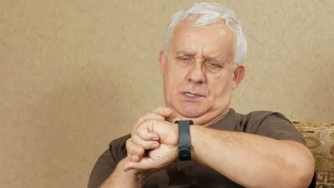 Senior man come messages on smart watches at home on the couch. He leafs through Stock Footage 71244564