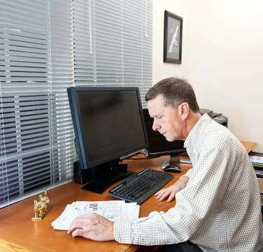 Senior man at computer desk Stock Photos