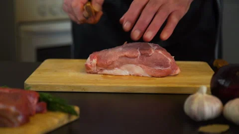 Senior Man Cutting Piece of Pork on Cutting Board Stock Footage 102499331