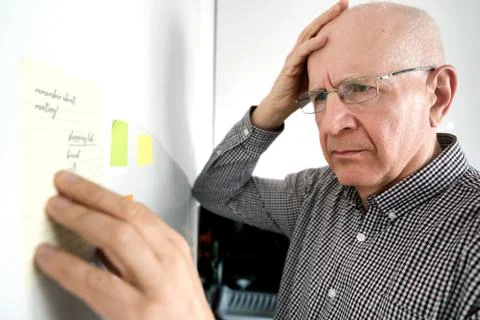 Senior man with dementia, looking at notes 스톡 사진