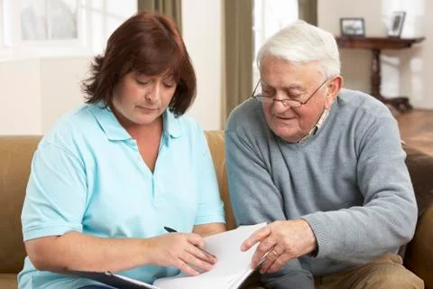 Senior Man In Discussion With Health Visitor At Home Stock Photos