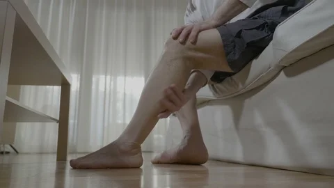 Senior man doing himself massage therapy on his tired legs relieve the pain a Video stock 88402115