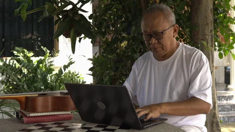 Senior man doing online work in the garden Stock Footage 253146861