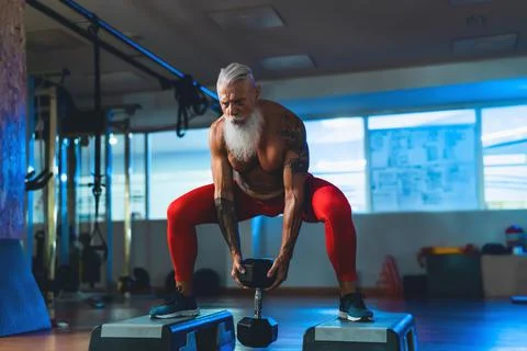 Senior man doing workout exercises inside gym - Fit mature male training Stock Photos