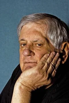 Senior man Dramatic side portrait of a senior man with his hand on the sid... Stock Photos