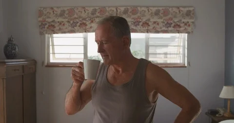 Senior man drinking coffee at home Stockbeeldmateriaal 122904565