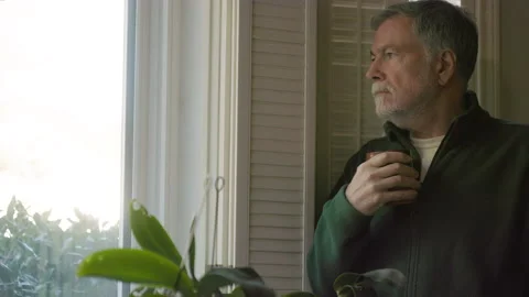 Senior man drinking coffee next to a window Stock Footage 164773200