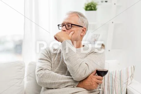 Senior man drinking red wine from glass at home Stock Photos