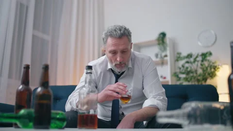 Senior man drinking whiskey alone, battling depression, relationship problems Stock Footage 202305468