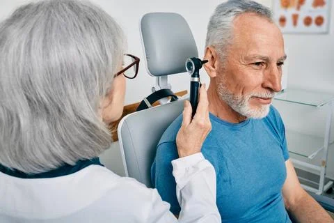 Senior man during ear test with audiologist at audiology. Diagnosis of impair Foto stock