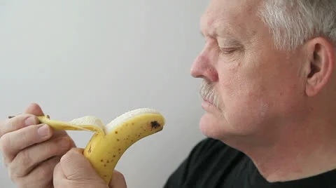 Senior man eats banana Stock Footage 22921160