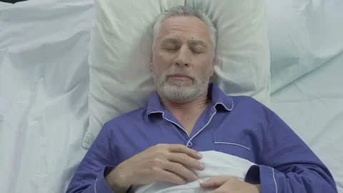 Senior man enjoying sleeping comfort due to orthopedic mattress and pillows Stock Footage